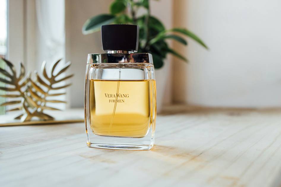 Close-up of elegant glass eau de toilette bottle with soft floral accents